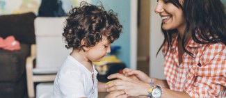 Mom smiling and talking to her son on the potty